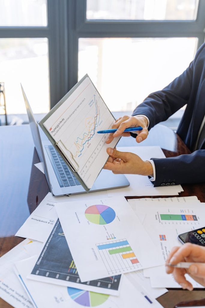 Expert en budget Business professionals discussing financial graphs and charts in an office setting.